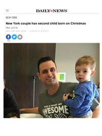 A man smiles while holding a young boy in his lap. The headline above reads, New York couple has second child born on Christmas, from Daily News.
