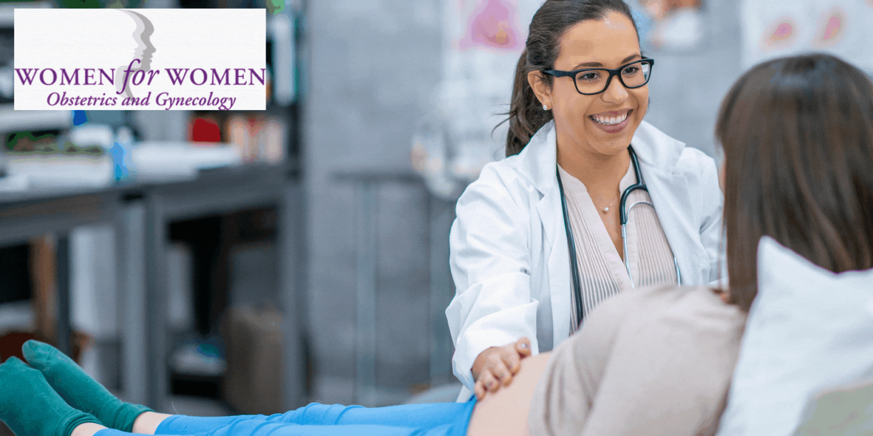 A smiling female doctor examines a pregnant woman in a medical office. The Women for Women Obstetrics and Gynecology logo is visible in the upper left corner, highlighting trusted care from a leading gyn in Elmont.